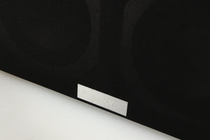 Close up of a used Tannoy Revolution DC4LCR Centre Speaker in an espresso finish showing scratching on grilles logo