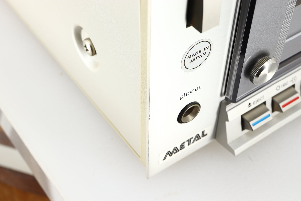 Close up of a used Technics RS-M225 Cassette Deck in a silver finish showing rough edge on front left corner