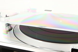Close up of a used Technics SL-1500C Turntable in a silver finish showing scratch on rear of lid