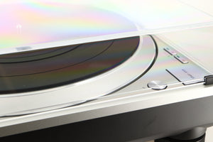 Close up of a used Technics SL-1500C Turntable in a silver finish showing light mark on left side