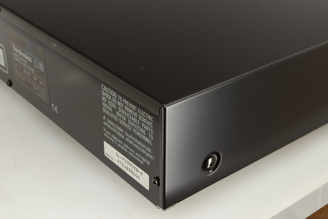Rear left corner of a used Technics SL-PG390EB-K CD Player in a grey finish