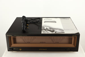 Top of a used Technics SE-A1000M2 Power Amplifier in a black finish showing Power Cable and Manual