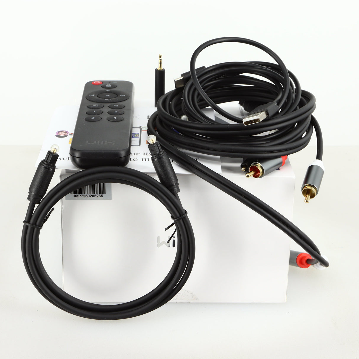 Box of a used Wiim Pro Plus Streamer showing a remote, manual, usb cable, interconnect cable, adaptor and optical cable