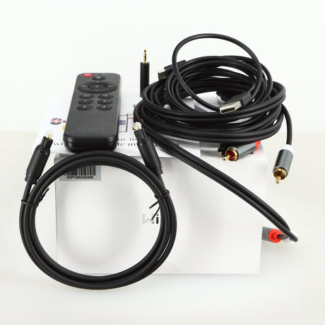 Box of a used Wiim Pro Plus Streamer showing a remote, manual, usb cable, interconnect cable, adaptor and optical cable