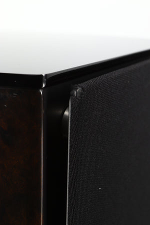 Close up of a used Wilson Benesch Vertex Standmount Speakers W/ Stands in a gloss walnut finish showing a small hole in the grille