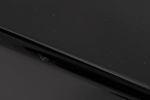 Close up of a used XTZ SA-1 Subwoofer in a Gloss Black finish sowing scratching on rear edge