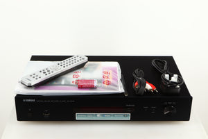 Top of a used Yamaha NP-S303 Musicast Streamer in a black finish showing Remote, Manual, 2x Batteries, Antenna, Interconnect Cable and Power Cable