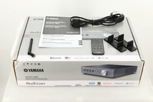 Box of a used Yamaha WXC-50 Streaming Pre Amplifier in Silver finish with mains cable, manual, remote, antenna, and stands 