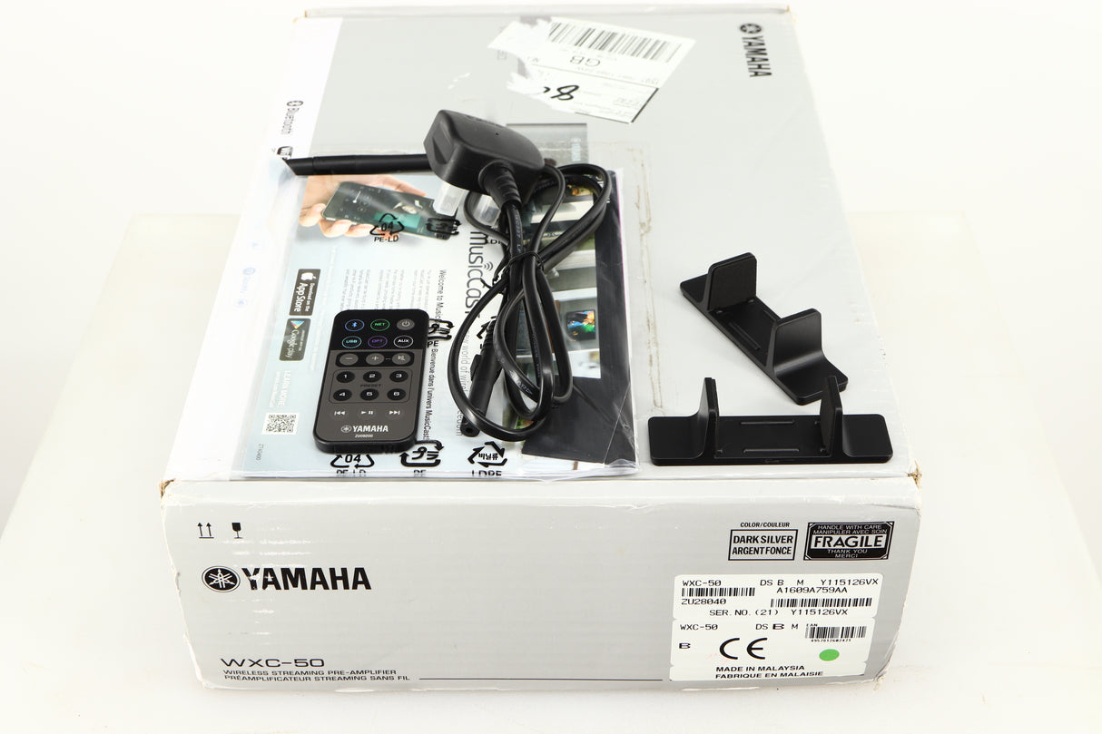 Box for a used Yamaha WXC-50 Streaming Pre Amplifier in a silver finish showing Remote, Power Cable, Aerial, Manual and 2x Wall Mounts