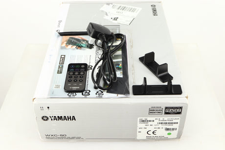 Box for a used Yamaha WXC-50 Streaming Pre Amplifier in a silver finish showing Remote, Power Cable, Aerial, Manual and 2x Wall Mounts